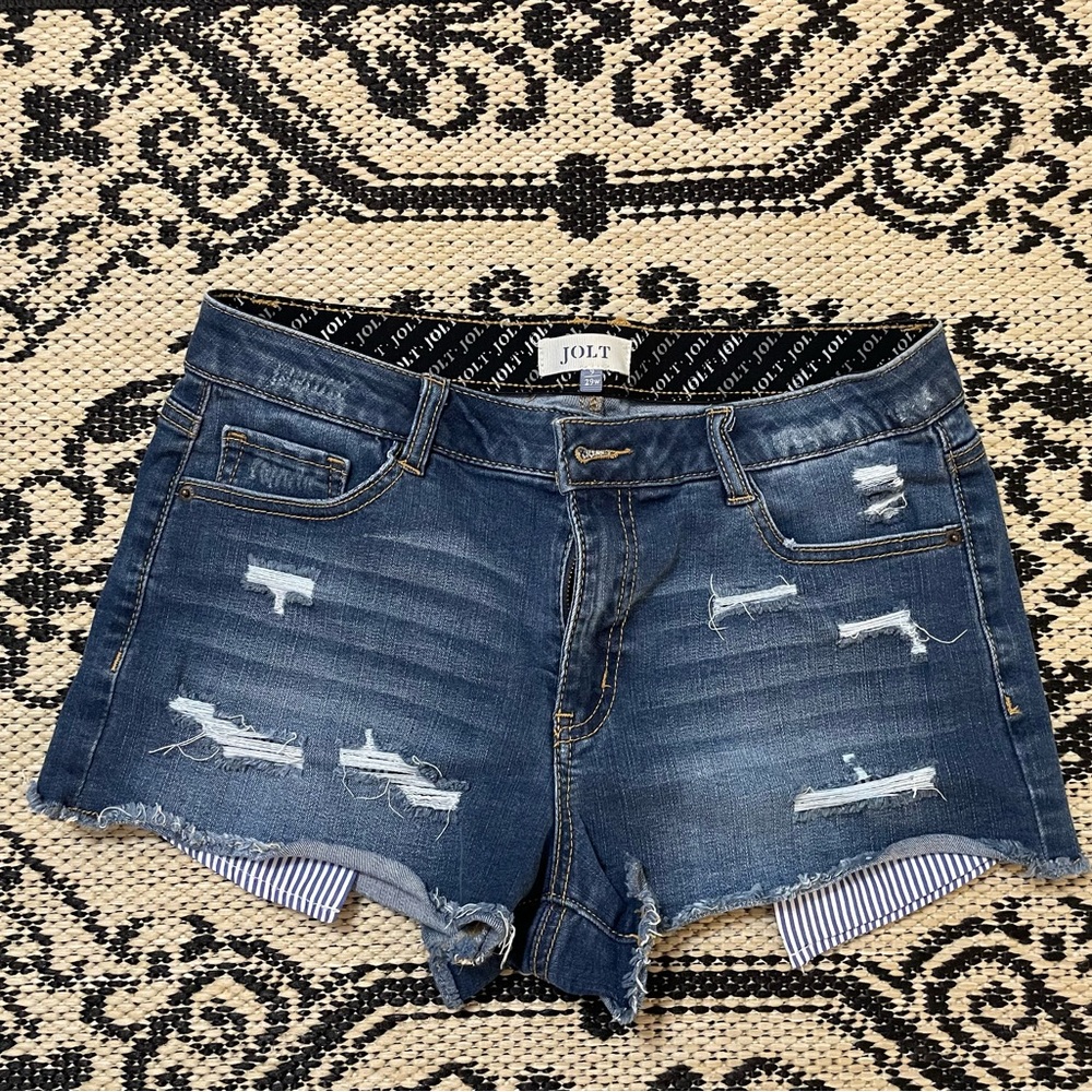 Jolt- Denim/ distressed cut off short with striped pocket inserts. Size 9/29